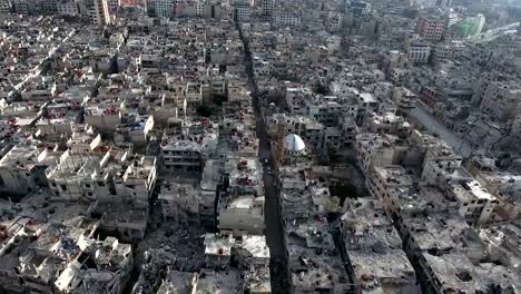 Aerial-view-of-ruined-homs-in-Syria,-birds-flying-in-the-sky