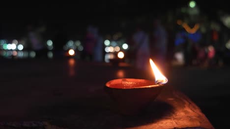 Lámpara-de-aceite-tierra-India-tradicional-con-mecha-de-algodón-ardiendo-en-el-lago-de-Pushkar