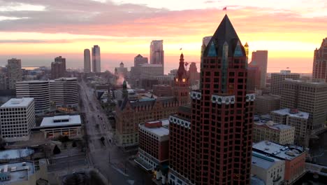 Luftaufnahme-von-Wolkenkratzern-in-amerikanischen-Stadt-in-der-Dämmerung.-Die-Innenstadt-von-Milwaukee,-Wisconsin,-Vereinigte-Staaten.-Drone-Schüsse,-Sonnenaufgang,-Sonnenlicht,-von-oben.