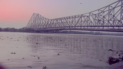 Ola-de-agua-en-el-río-de-ganga-contaminado-cerca-de-puente-de-Howrah,-Kolkata-(India)-en-la-hora-del-atardecer