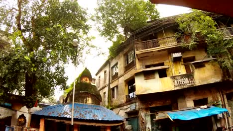 edificios-en-mal-estado-cubiertos-de-árboles-antigua-calle-de-Kolkata-techo-de-templo-hindú