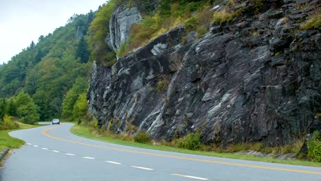 Familia-Sedán-por-Blue-Ridge-Parkway-después-de-pared-de-piedra