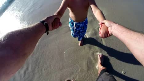 Cámara-lenta-punto-de-vista-del-padre-balanceo-niño-feliz-en-la-playa.