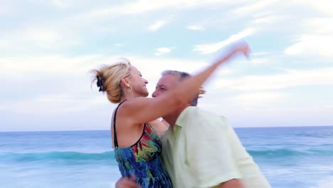An-older-couple-being-playful-on-the-beach