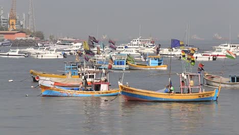 Hölzerne-Fischerboote-und-teuren-Yachten-auf-dem-Meerwasser,-Mumbai,-Indien