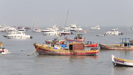 Hölzerne-Fischerboote-und-teuren-Yachten-auf-dem-Meerwasser,-Mumbai,-Indien