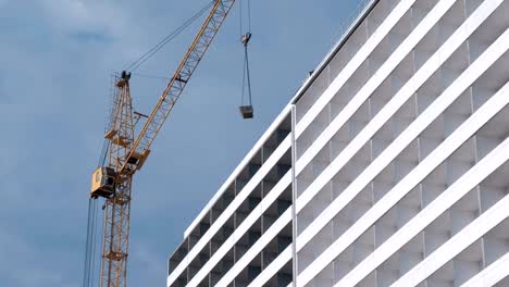 Construcción-de-un-edificio-de-varios-pisos.-Casa-y-construcción-de-la-grúa-sobre-fondo-de-cielo.