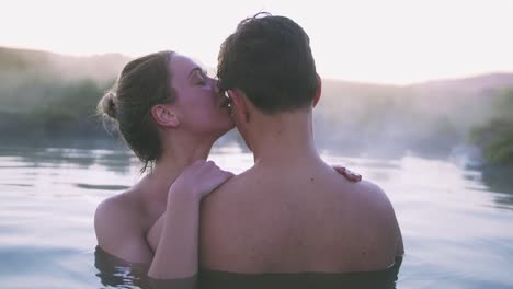 Happy-couple-in-love-bathing-and-relaxing-in-hot-pool-in-wild-landscape