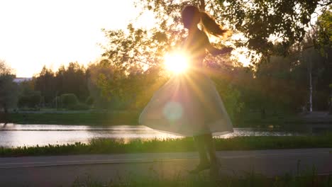 Girl-spin-around-in-airy-dress-against-setting-sun.