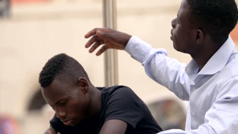 Family-support.-sad-young-black-man-is-comforted-by-his-old-brother--outdoor