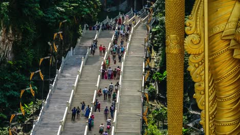 Flujo-turístico-a-pasos-de-las-escaleras-cerca-de-señor-Murugan-estatua-de-deidad-hindú-en-las-cuevas-de-Batu-en-Timelapse-de-Malasia-4K