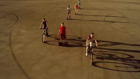 Cheerful-children-riding-on-wheeled-urban-vehicles-rolling-right-to-the-camera