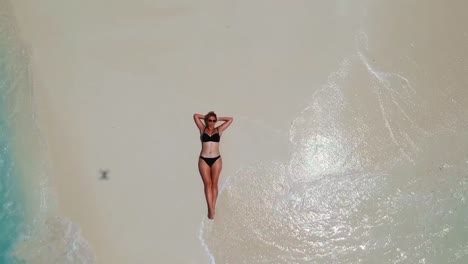 Gorgeous-woman-basks-on-sand-tongue-surrounded-by-turquoise-water