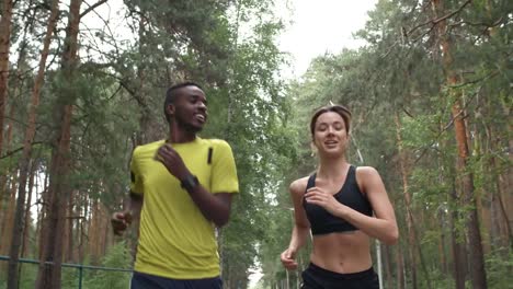 Hombre-alegre-y-mujer-para-correr-en-el-bosque