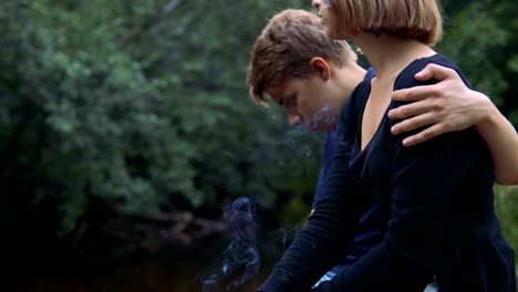 Enamored-teenagers-sit-in-the-background-of-nature-and-talk-with-each-other.