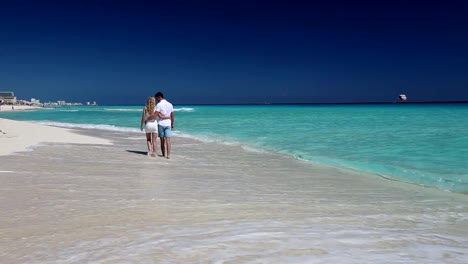 Junges-Paar-zu-Fuß-am-Strand