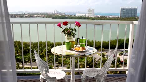 Delicious-breakfast--with-coffee-fresh-croissants-and-slice-of-orange-fruit-on-balcony