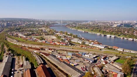 Vista-aérea-panorámica-de-360-grados-de-la-ciudad,-en-la-estación-de-trenes-y-estación-de-autobuses,-al-río,-puentes