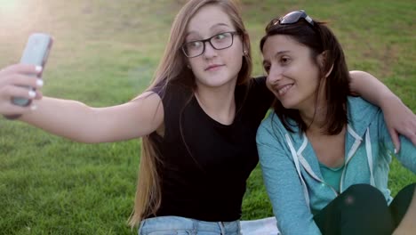 Teenage-girl-with-her-mother-taking-self-ie-in-the-park