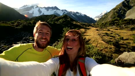 Young-couple-take-self-portrait-on-mountain-background