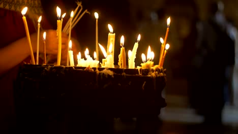 Close-up-of-prayers-hands-lighting-candles-in-the--Church-of-The-Holy-Sepulchre-in-Jerusalem