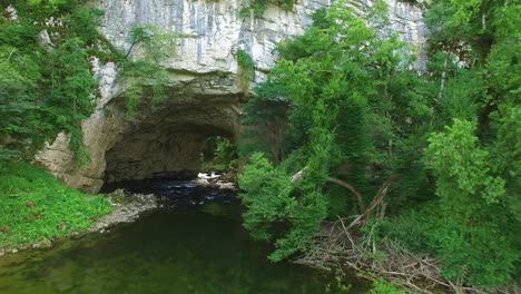 River-Running-Through-Cave-At-Summer