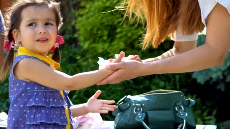 A-young-woman-is-wiping-her-daughter's-hands.