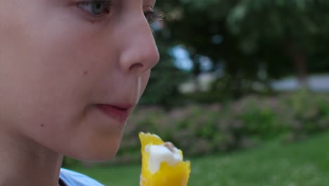 Chica-adolescente-de-retrato-comiendo-helado-amarillo-extremo-de-cerca