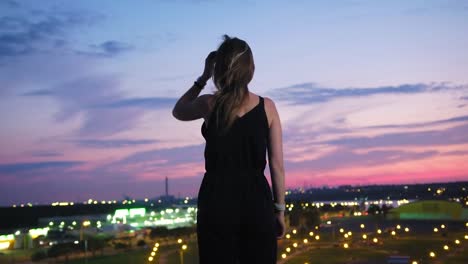 Hintere-Ansicht-junge-Frau-genießen-Sie-herrlichen-Blick-auf-moderne-Stadt-stehen-auf-dem-Dach