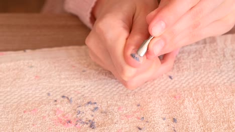 Woman-removes-shellac-from-nail-with-pusher.-Close-up-hand.