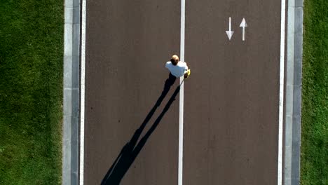 The-elderly-man-rollerblading-on-the-road.-view-from-above,-quadrocopter-shot