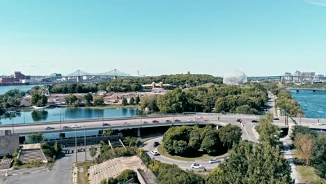 Luftbild-Drohne-Footage-von-Montreal-mit-Brücken-und-einem-Park-Bereich-plus-Ile-Sainte-Helene-Insel-mit-der-Biosphäre-Kuppel-im-Hintergrund