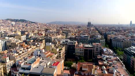 Aerial-above-Barcelona-Eixample-district-rooftops,-morning-light,-Spain