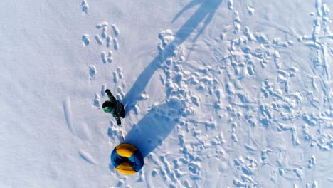 Jungen-von-7-Jahren-ist-mit-dem-Schlauch-im-Schnee-Wirbeln.-Luftaufnahmen.