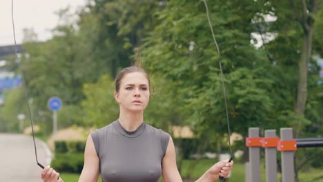 Athlete-woman-using-skipping-rope-for-outdoor-workout-in-summer-park