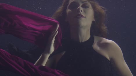 Geheimnisvolle-Frau-in-chiffon-Kleid-Unterwasser-Schwimmbad-auf-dunklem-Hintergrund.