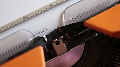 Close-up-footage-of-an-old-typewriter-and-a-person-writing-NUCLEAR-WAR-on-it...