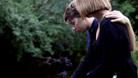 Enamored-teenagers-sit-in-the-background-of-nature-and-talk-with-each-other.