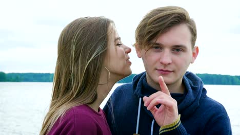 Portrait-of-two-teenagers,-a-guy-and-a-girl,-against-the-background-of-a-river-and-forest.