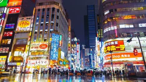 Distrito-de-Shinjuku-en-noche-lluviosa-con-paso-de-peatones-de-paso-público.-Tokio,-Japón.-Timelapse-de-4K.