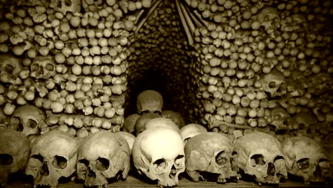 4K-footage-of-Human's-bones-and-skulls-in-the-underground-catacombs-with-old-chronicle-film-effect-after-processing.