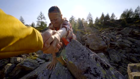 Teammate-helping-hiker-to-reach-summit.-Couple-hiking-in-Switzerland,-hand-reach-out-to-help-female-hiker-reach-the-summit.-A-helping-hand-concept