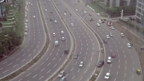 View-of-a-wide-road-and-passing-vehicles-along-the-business-centre-town-of-north-Indian,-Gurgaon--a-major-financial-and-infrastructural-hub