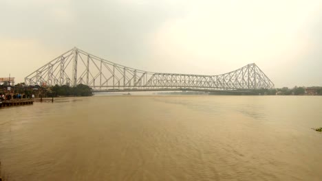 Howrah-Brücke-unter-dem-Fluss-Hoogli-Fähranlegestelle-mit-Menschen-bewölkt-Tag-Kolkata