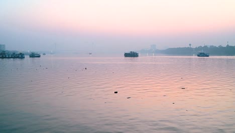 Barco-que-se-mueve-sobre-el-río-Ganges-en-la-ciudad-de-Calcuta-en-el-momento-de-Sunset-cerca-de-Vidyasagar-setu-o-segundo-puente-Hooghly-en-Bengala-Occidental,-India.