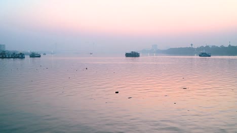 Boot-bewegt-sich-über-Ganges-Fluss-in-Kolkata-Stadt-zur-Zeit-von-Sonnenuntergang-in-der-Nähe-von-Vidyasagar-setu-oder-zweite-Hooghly-Bridge-in-Westbengalen,-Indien.