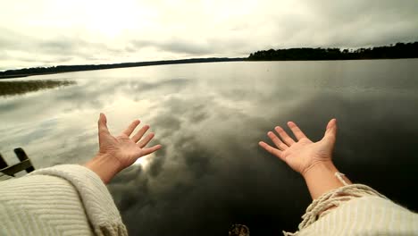 Woman's-arms-stretch-towards-mountain-lake,-success-concept