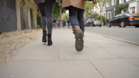 Cerca-de-pies-de-la-pareja-caminando-por-la-calle-de-la-ciudad