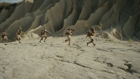 Squad-of-Fully-Equipped,-Armed-Soldiers-Running-in-the-Desert.