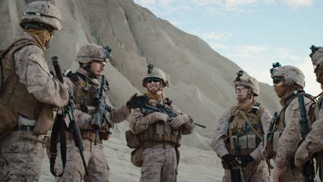 Group-of-Soldiers-are-Standing-in-a-Circle-and-Listening-Orders-from-Commander-During-Briefing-before-Military-Operation-in-the-Desert.